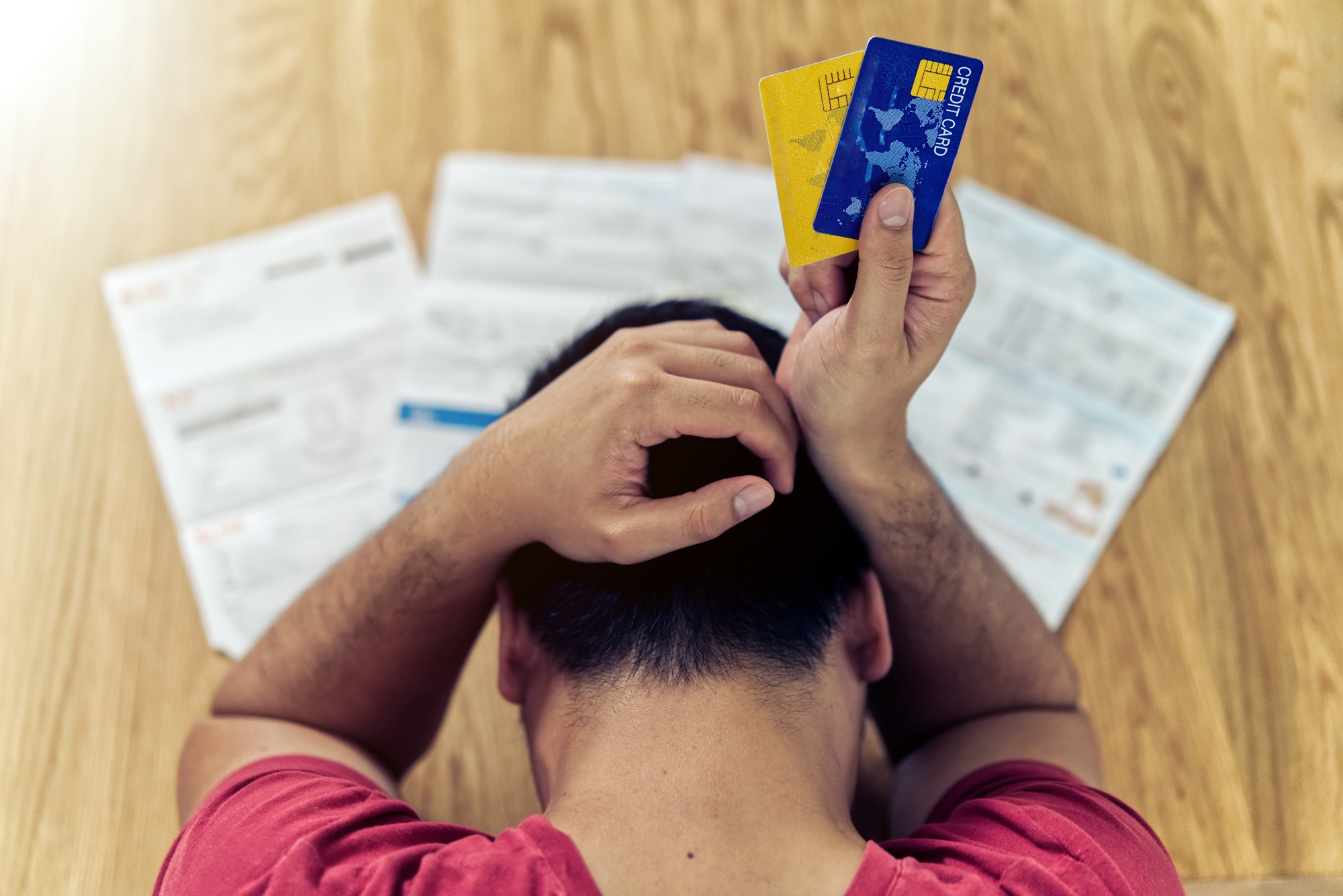 Asian man holding credit cards and thinking about finding money to pay for debt and all bills Asian man holding credit cards and thinking about finding money to pay for debt and all bills
