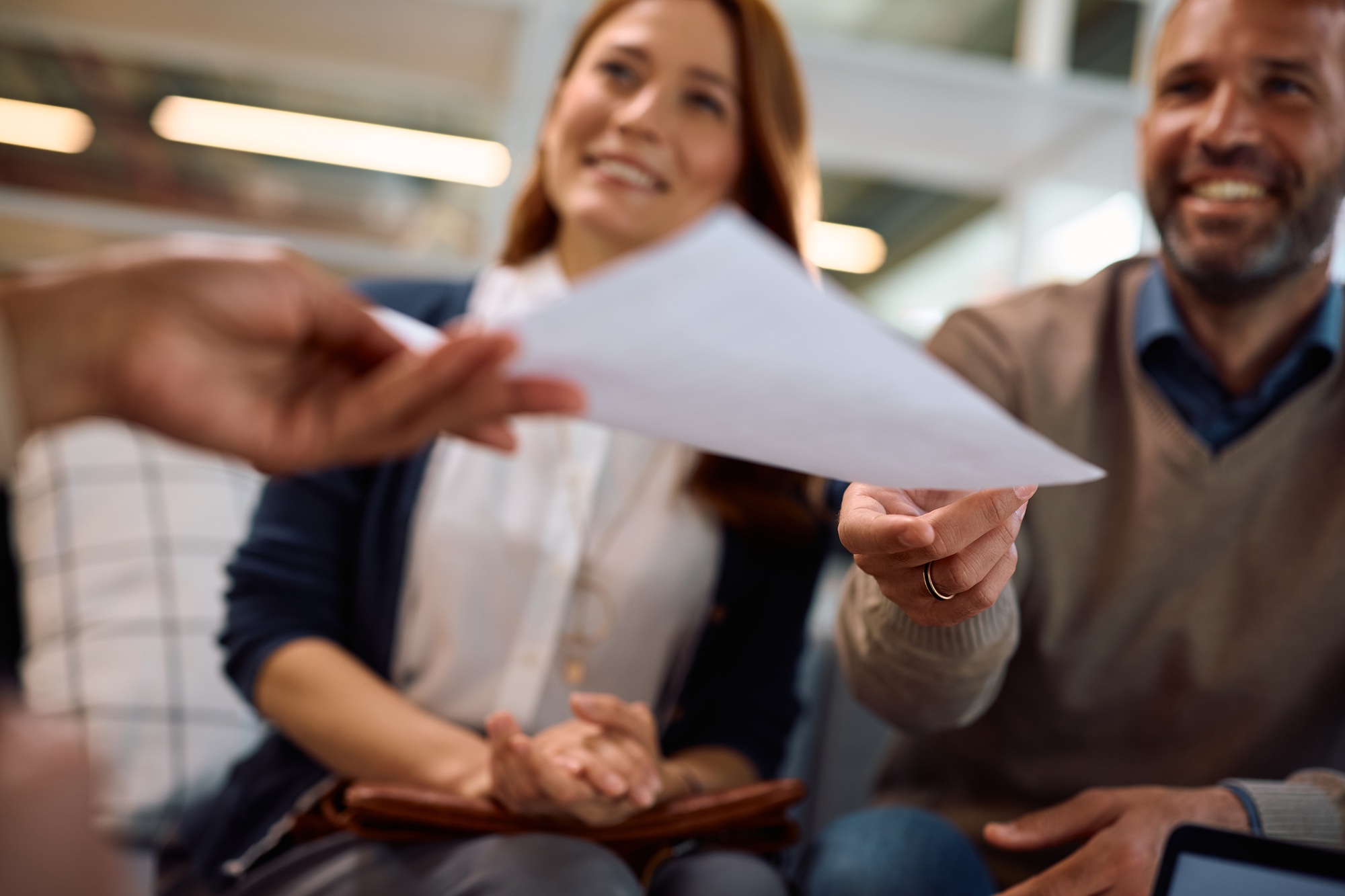 Close up of couple giving documents to a bank manager during a meeting in the office. Close up of couple giving documents to a bank manager during a meeting in the office.