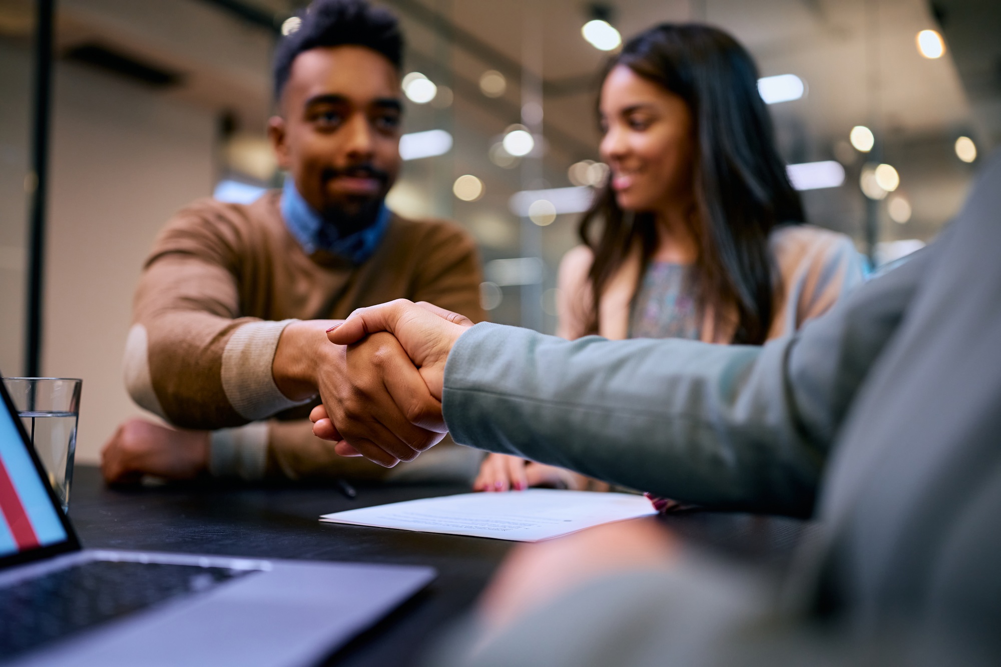 Close up of insurance agent handshaking with a client in the office. Close up of insurance agent handshaking with a client in the office.