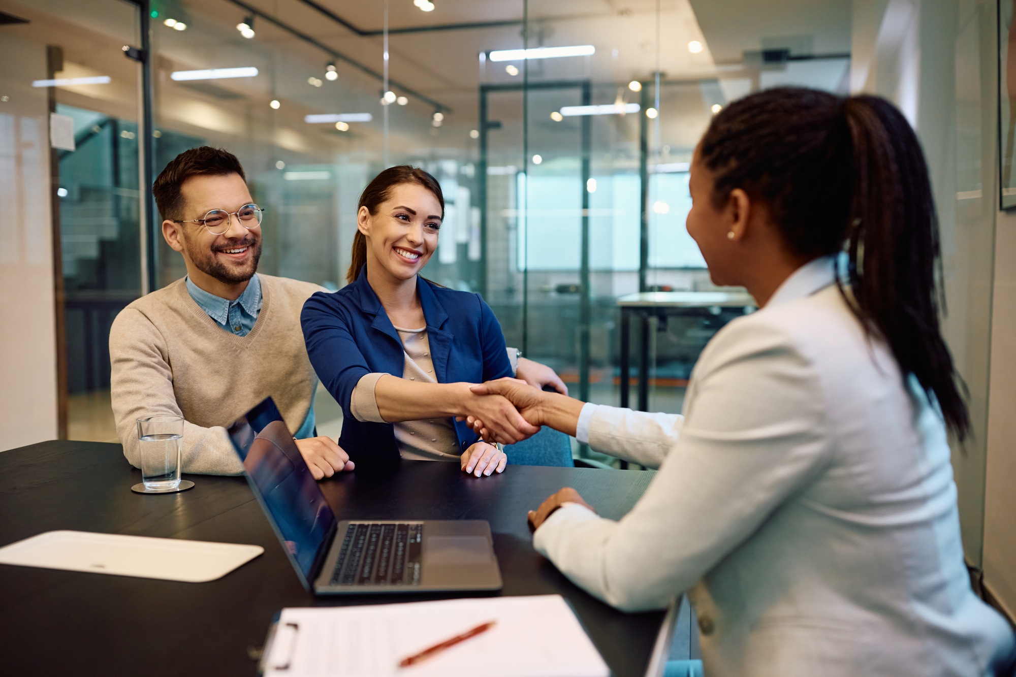 Happy couple greeting their financial advisor in the office.