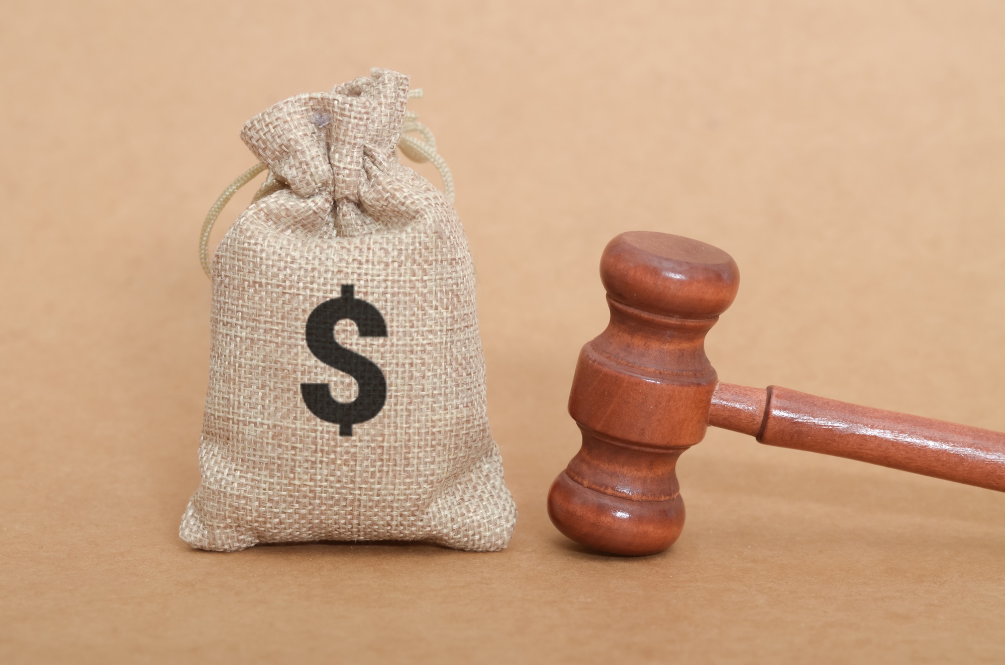 Money and Justice Concept – Burlap Sack with Dollar Sign and Judge’s Gavel