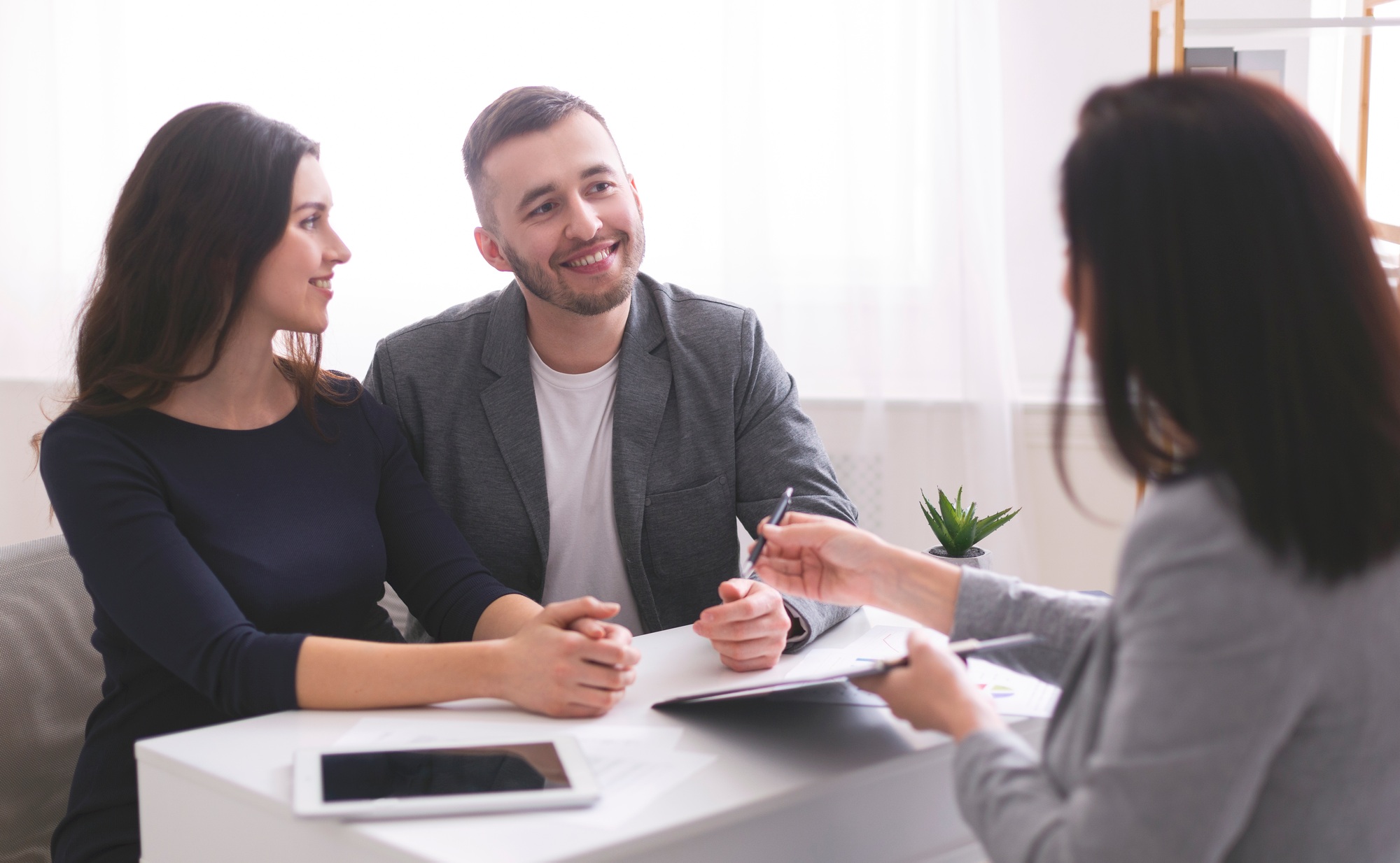 Young family listening to financial advisor, ready to sign credit contract Young family listening to financial advisor, ready to sign credit contract